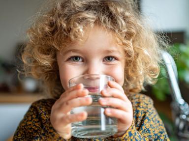 Kind trinkt frisches Leitungswasser aus einem Glas