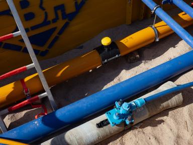 Nahaufnahme von Gas- und Wasserleitungen in einer Baugrube.