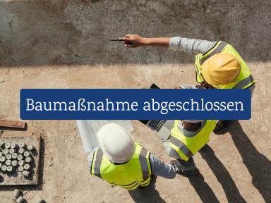 Baustellenbesprechung: Drei Bauingenieure mit Helm und Warnweste planen ein Projekt mit Laptop und Bauplänen