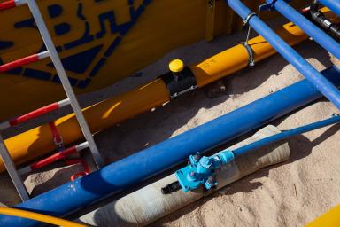 Nahaufnahme von Gas- und Wasserleitungen in einer Baugrube.
