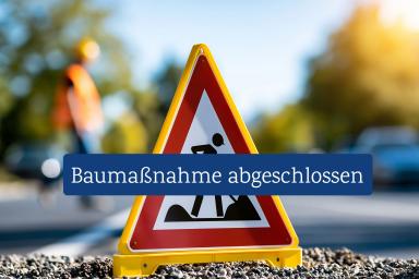 Baustelle auf der Straße – deutlich gekennzeichnetes Warnschild im Vordergrund