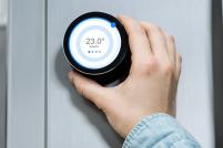 eine Hand, die ein Thermostat dreht