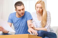 Ein Mann und eine Frau schauen sich Papiere auf einem Tisch an.