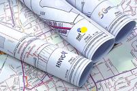 mehrere zusammengerollte Baupläne auf einer Karte